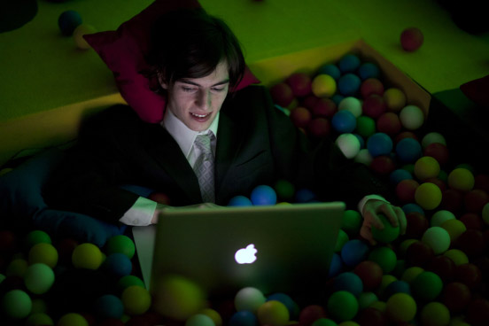 Photograph of Andy sitting in a suit with a MacBook in a ball pit taken during the 27th Chaos Communication Congress (27C3) in 2010